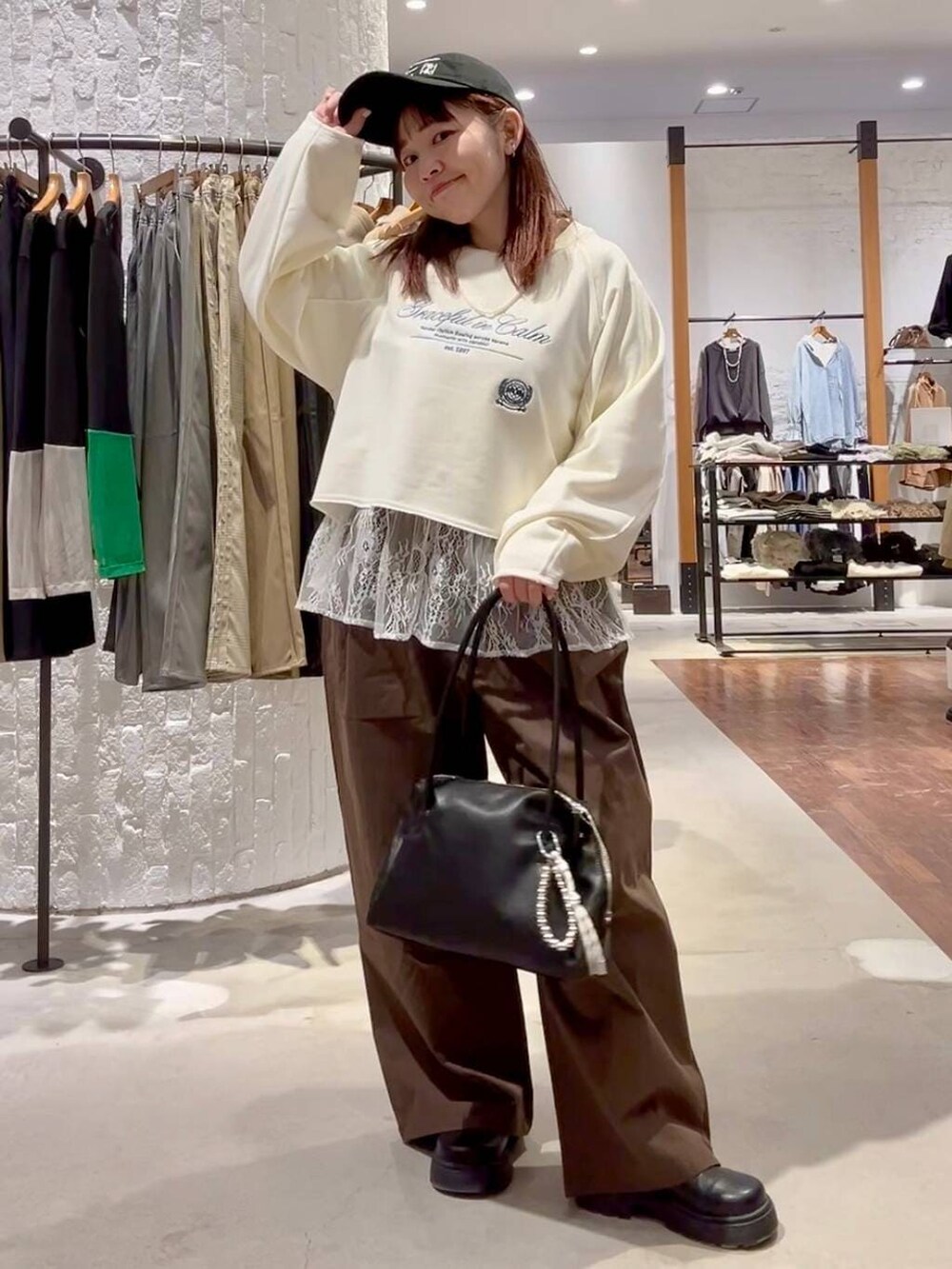 ホワイト系のTシャツ/カットソー、グリーン系のその他パンツ、ブラック系のボストンバッグを着用したレディースの冬コーディネートの7枚目の写真