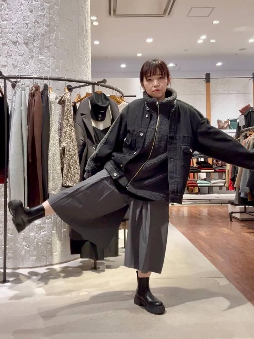 ブラック系のブーツ、ブラック系のデニムジャケット、ブラック系のハンドバッグを着用したレディースの秋コーディネートの6枚目の写真