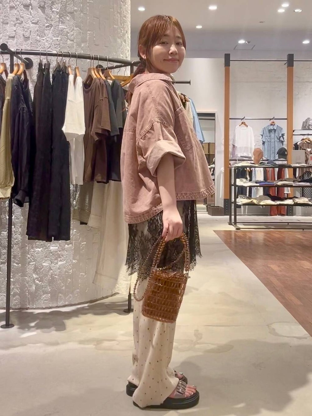 ベージュ系のその他パンツ、その他のサンダル、ブラウン系のショルダーバッグを着用したレディースの夏コーディネートの3枚目の写真