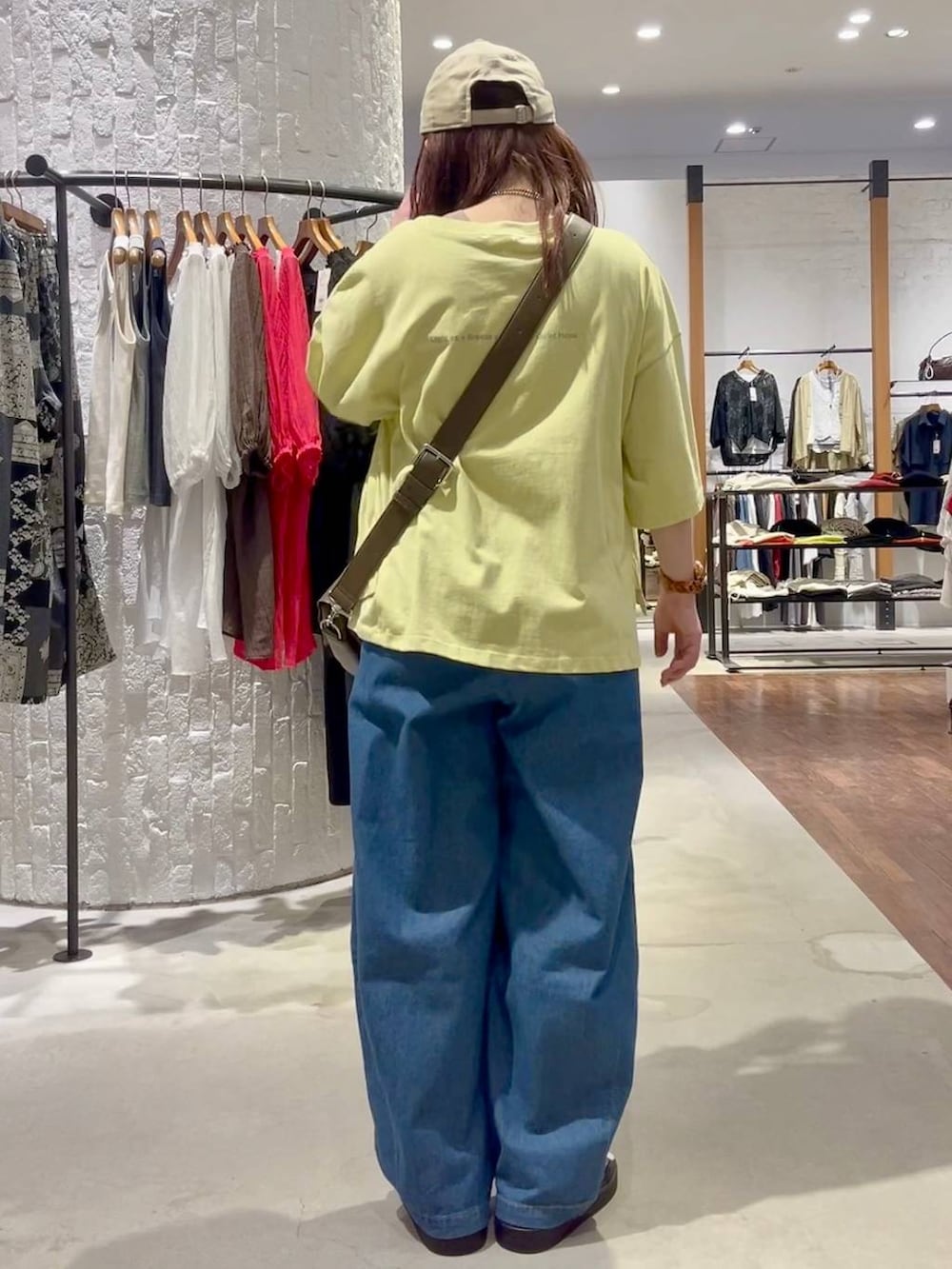ブラウン系のショルダーバッグ、ホワイト系のサンダル、ブルー系のデニムパンツを着用したレディースの春コーディネートの4枚目の写真