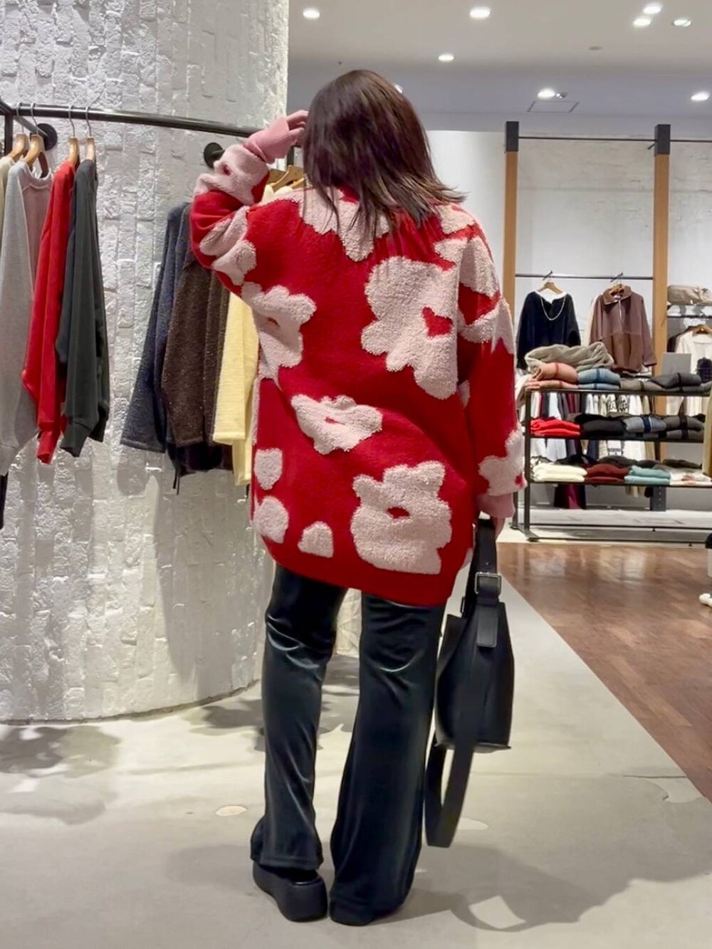 グレー系のニット/セーター、ブルー系のその他パンツ、ブラック系のショルダーバッグを着用したレディースの秋コーディネートの5枚目の写真