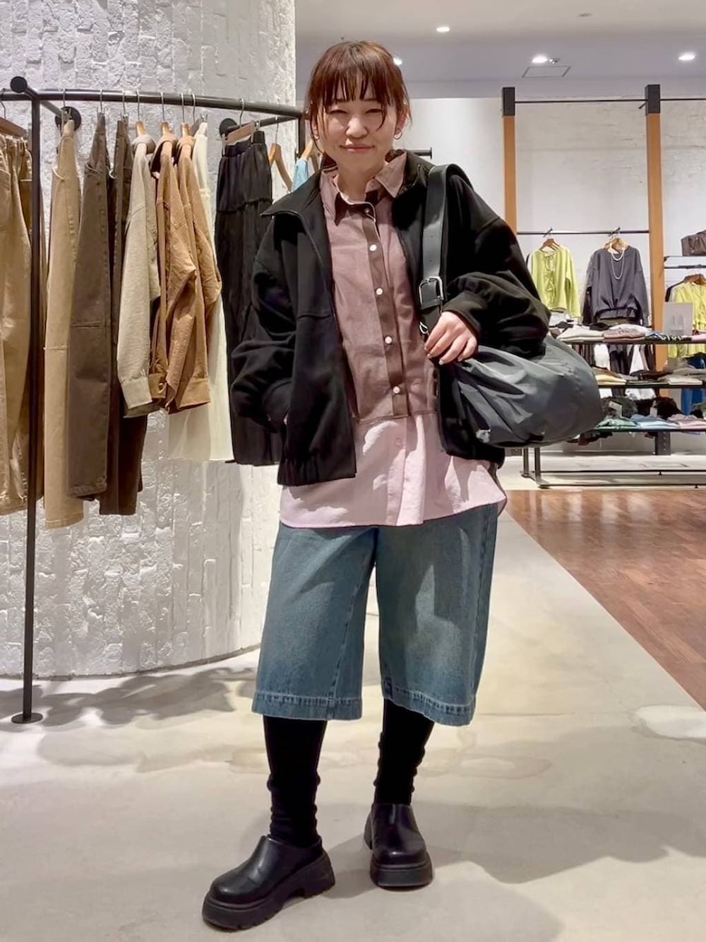 ブラック系のその他シューズ、ブラック系のブルゾン、ブラック系のショルダーバッグを着用したレディースの春コーディネートの2枚目の写真