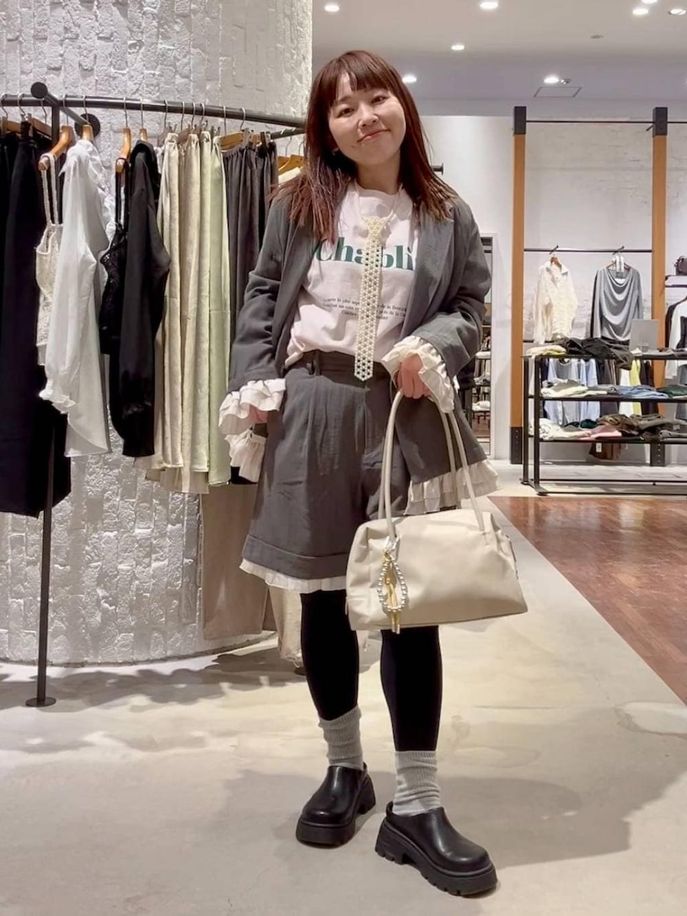 ホワイト系のボストンバッグ、ブラック系のその他シューズ、ピンク系のTシャツ/カットソーを着用したレディースの春コーディネートの2枚目の写真