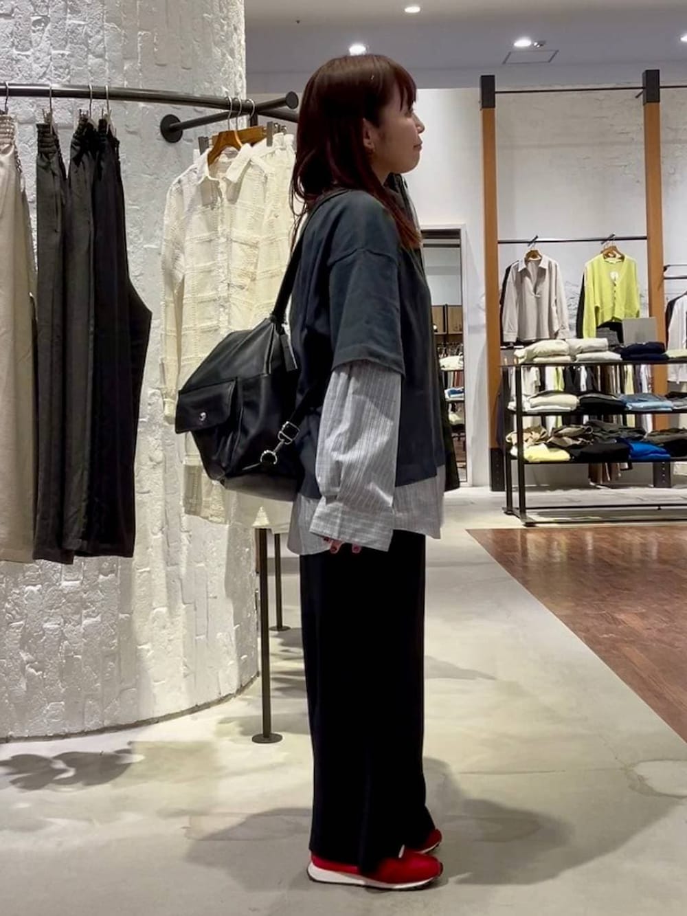 ブラック系のショルダーバッグ、レッド系のスニーカー、グレー系のTシャツ/カットソーを着用したレディースの春コーディネートの3枚目の写真