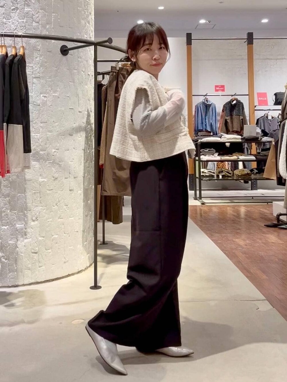 ホワイト系のTシャツ/カットソー、ブラック系のサロペット/オーバーオール、ベージュ系のその他アウターを着用したレディースの冬コーディネートの3枚目の写真