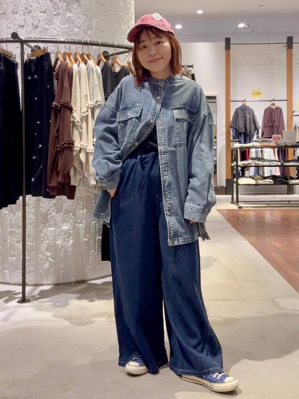 ブラック系のTシャツ/カットソー、ブルー系のスニーカー、ブルー系のデニムパンツを着用したレディースの秋コーディネートの2枚目の写真