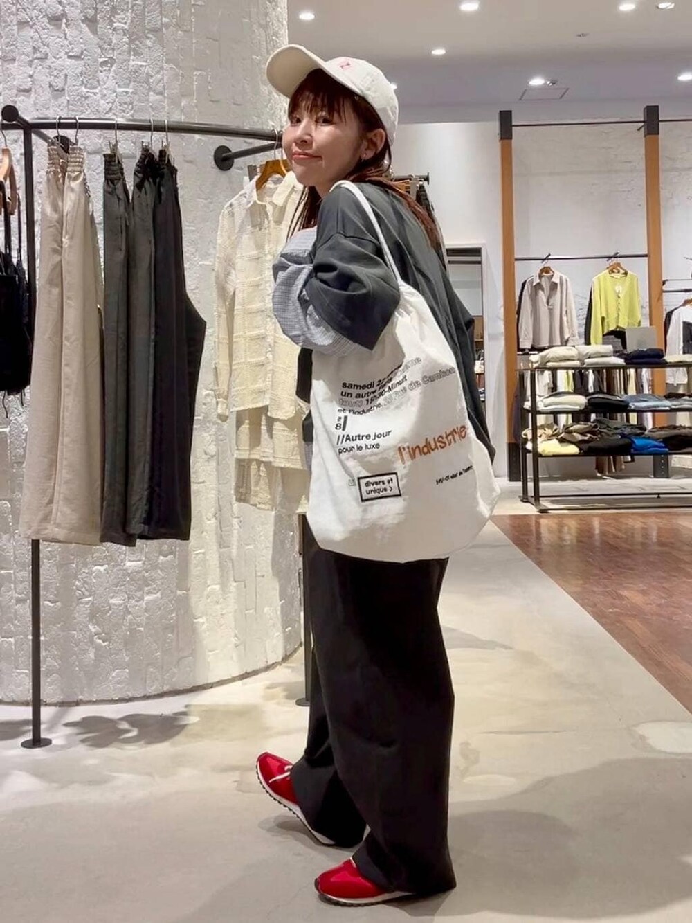 レッド系のスニーカー、ホワイト系のトートバッグ、グレー系のTシャツ/カットソーを着用したレディースの春コーディネートの4枚目の写真