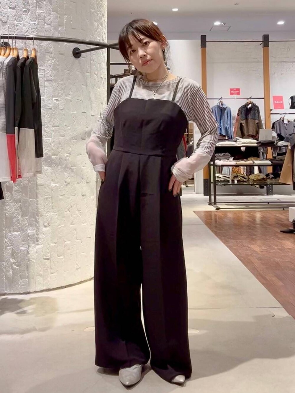 ホワイト系のTシャツ/カットソー、ブラック系のサロペット/オーバーオール、ベージュ系のその他アウターを着用したレディースの冬コーディネートの6枚目の写真