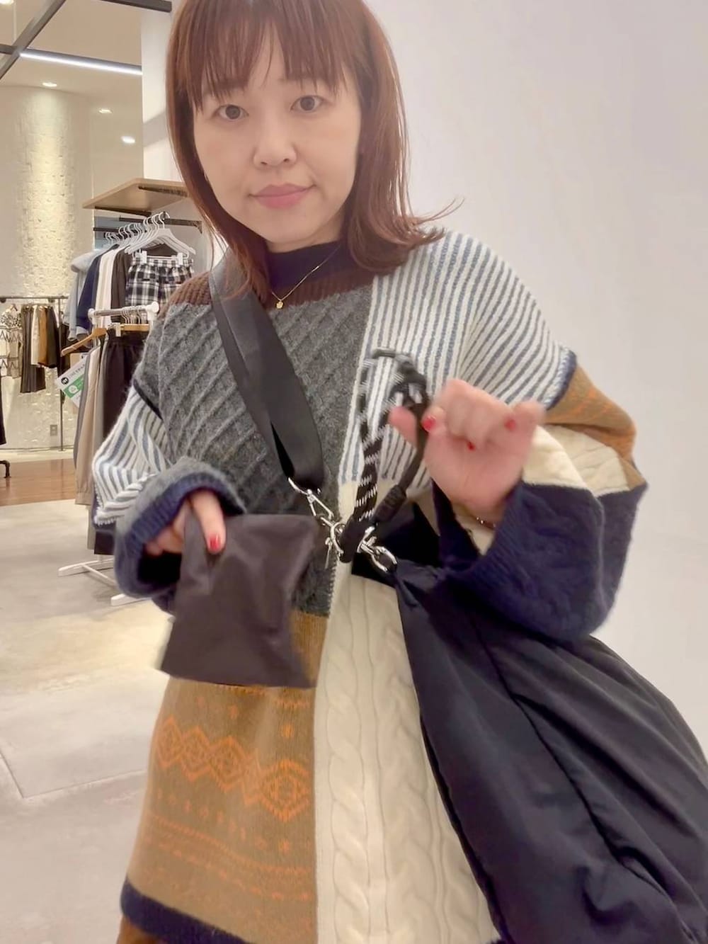 ブルー系のスニーカー、イエロー系のその他パンツ、ブラウン系のニット/セーターを着用したレディースの秋コーディネートの6枚目の写真