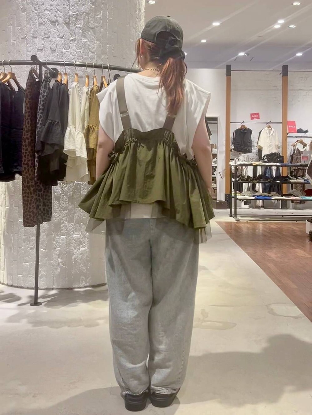 グリーン系のベスト、その他のサンダル、ブルー系のデニムパンツを着用したレディースの夏コーディネートの4枚目の写真