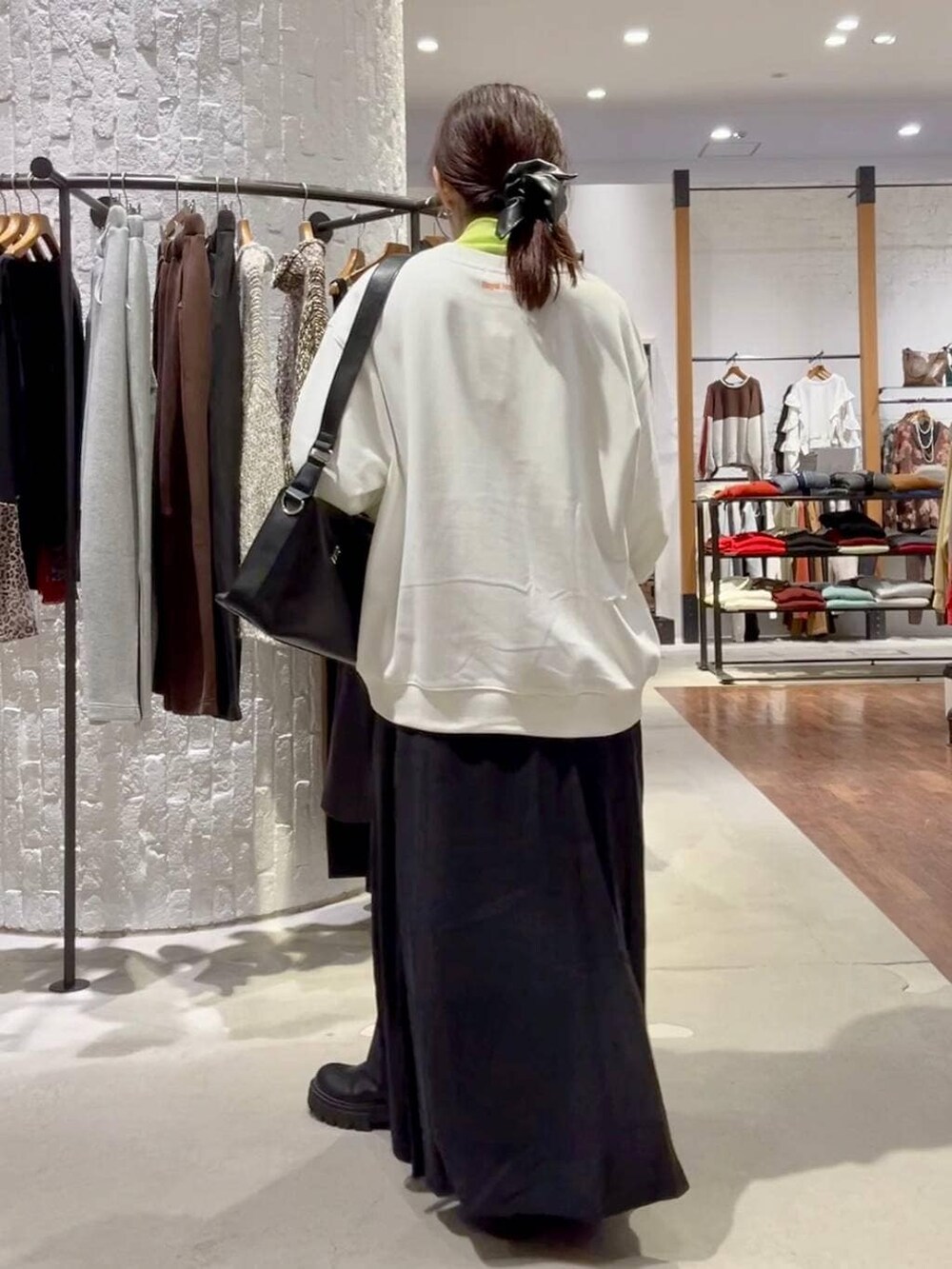 ブラック系のショルダーバッグ、ブラック系のその他アウター、ブラック系のブーツを着用したレディースの冬コーディネートの8枚目の写真