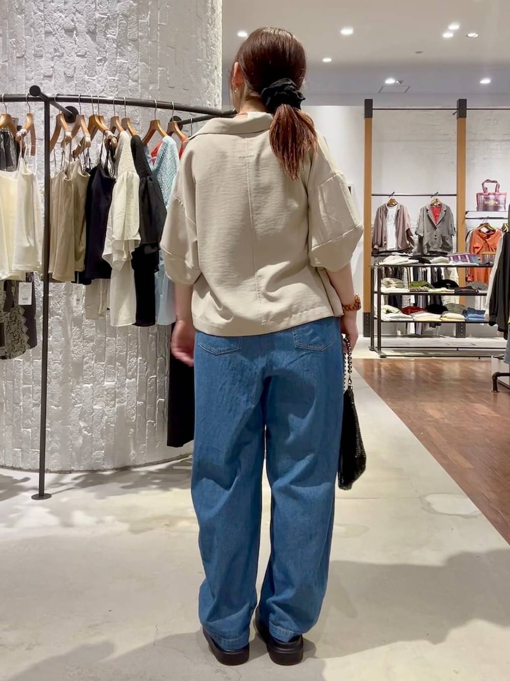 ブラック系のサンダル、ベージュ系のテーラードジャケット、ブラック系のショルダーバッグを着用したレディースの春コーディネートの4枚目の写真