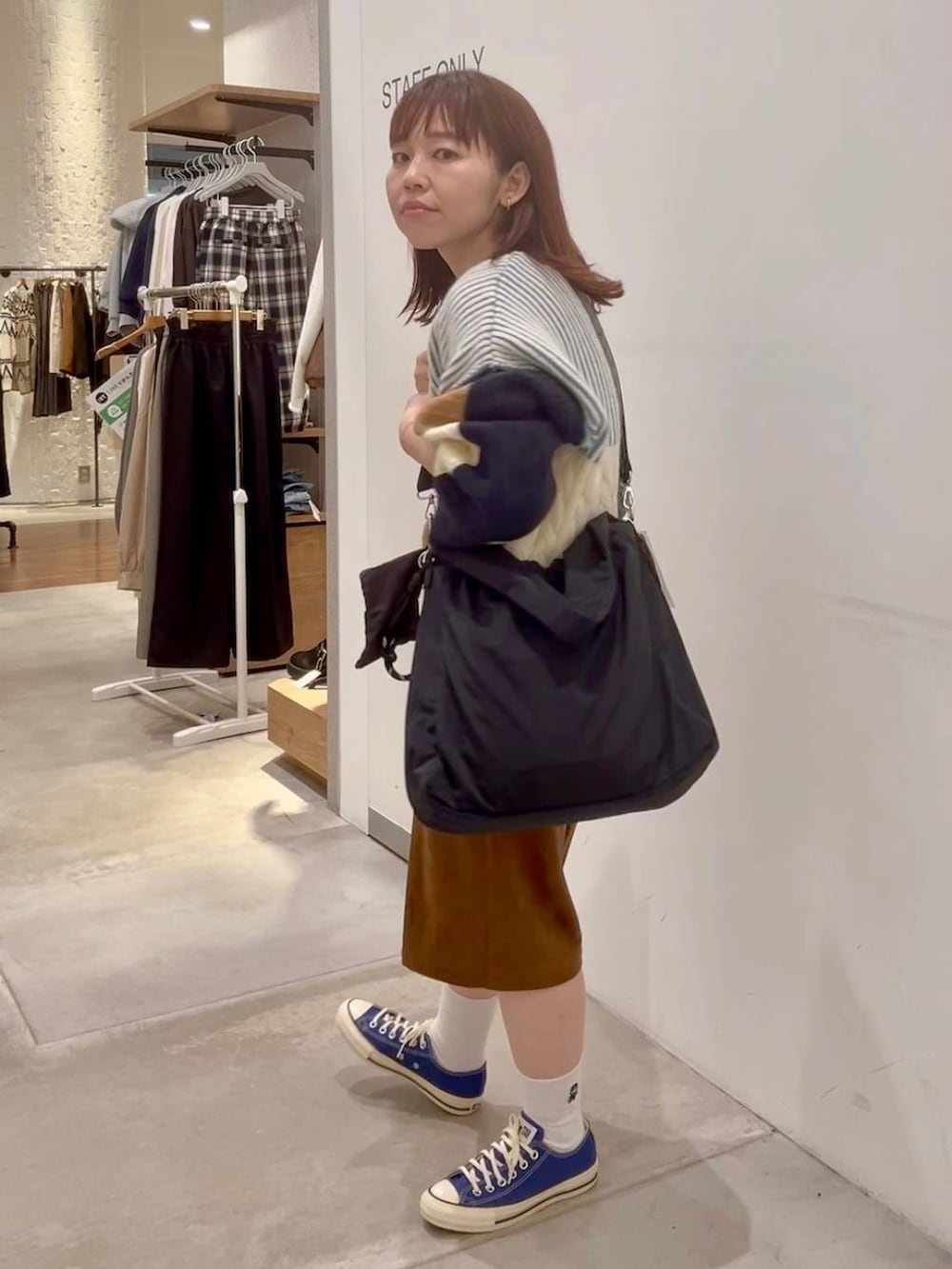 ブルー系のスニーカー、イエロー系のその他パンツ、ブラウン系のニット/セーターを着用したレディースの秋コーディネートの5枚目の写真