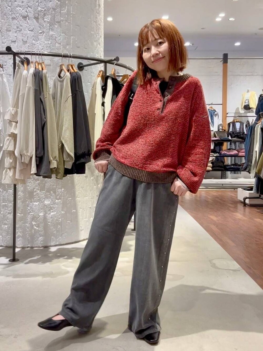 ブラック系のTシャツ/カットソー、グレー系のデニムパンツ、レッド系のニット/セーターを着用したレディースの秋コーディネートの2枚目の写真