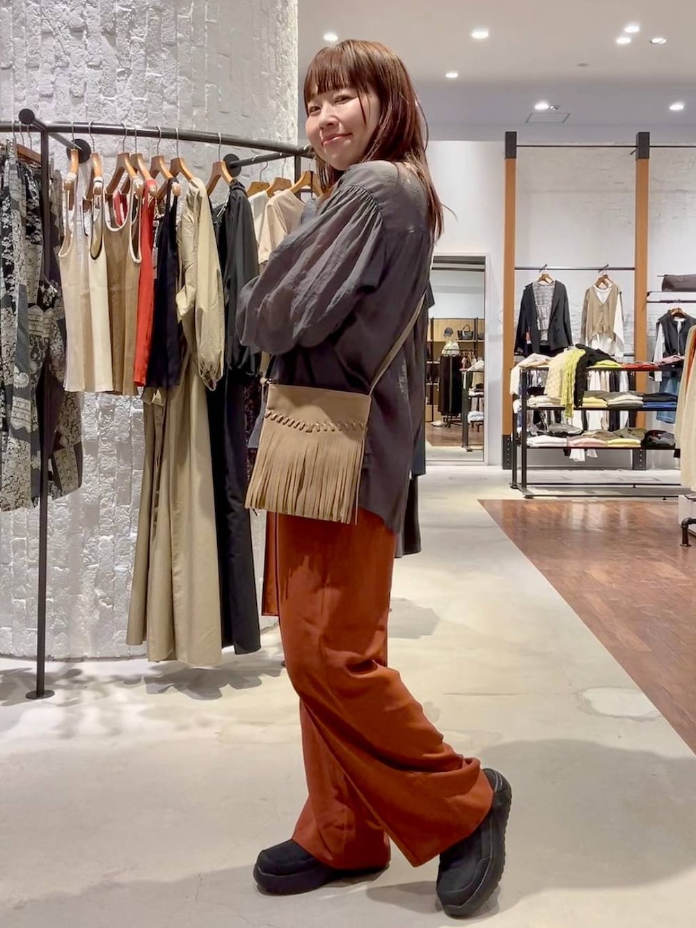 ブラック系のその他シューズ、ブラウン系のショルダーバッグ、ホワイト系のTシャツ/カットソーを着用したレディースの春コーディネートの3枚目の写真