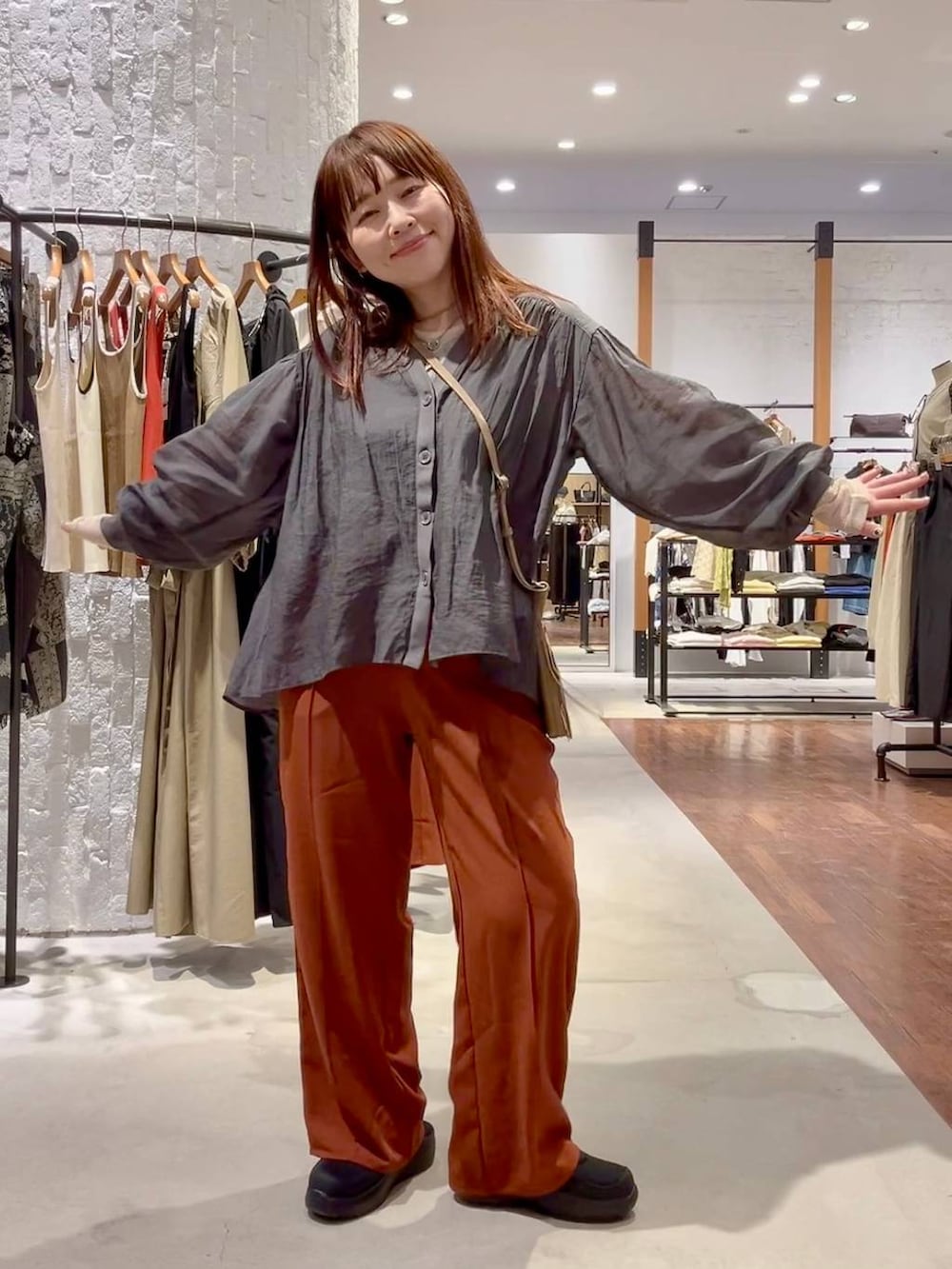 ブラック系のその他シューズ、ブラウン系のショルダーバッグ、ホワイト系のTシャツ/カットソーを着用したレディースの春コーディネートの2枚目の写真