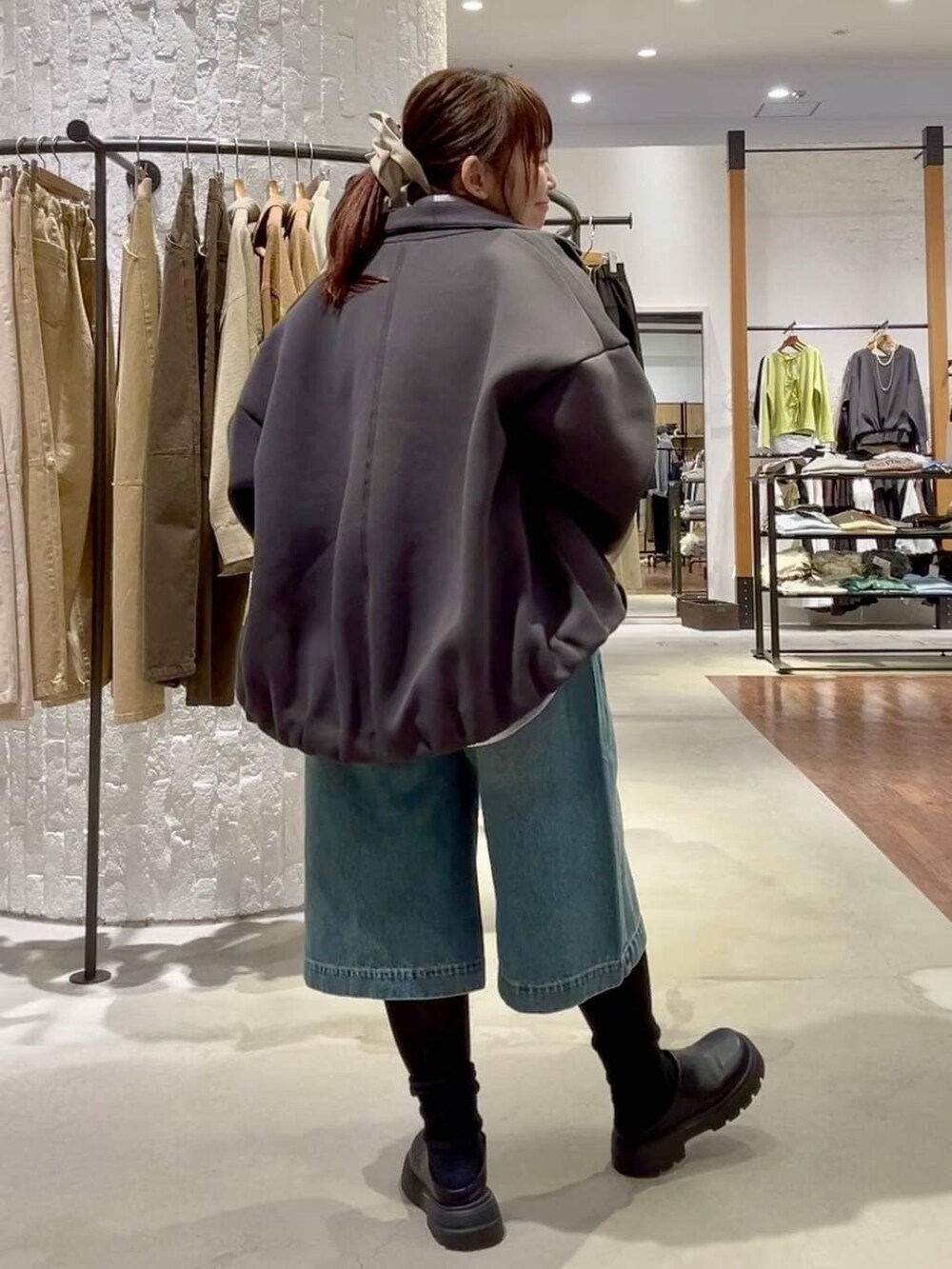 ブラック系のその他シューズ、ブラック系のボストンバッグ、ブルー系のデニムパンツを着用したレディースの冬コーディネートの4枚目の写真