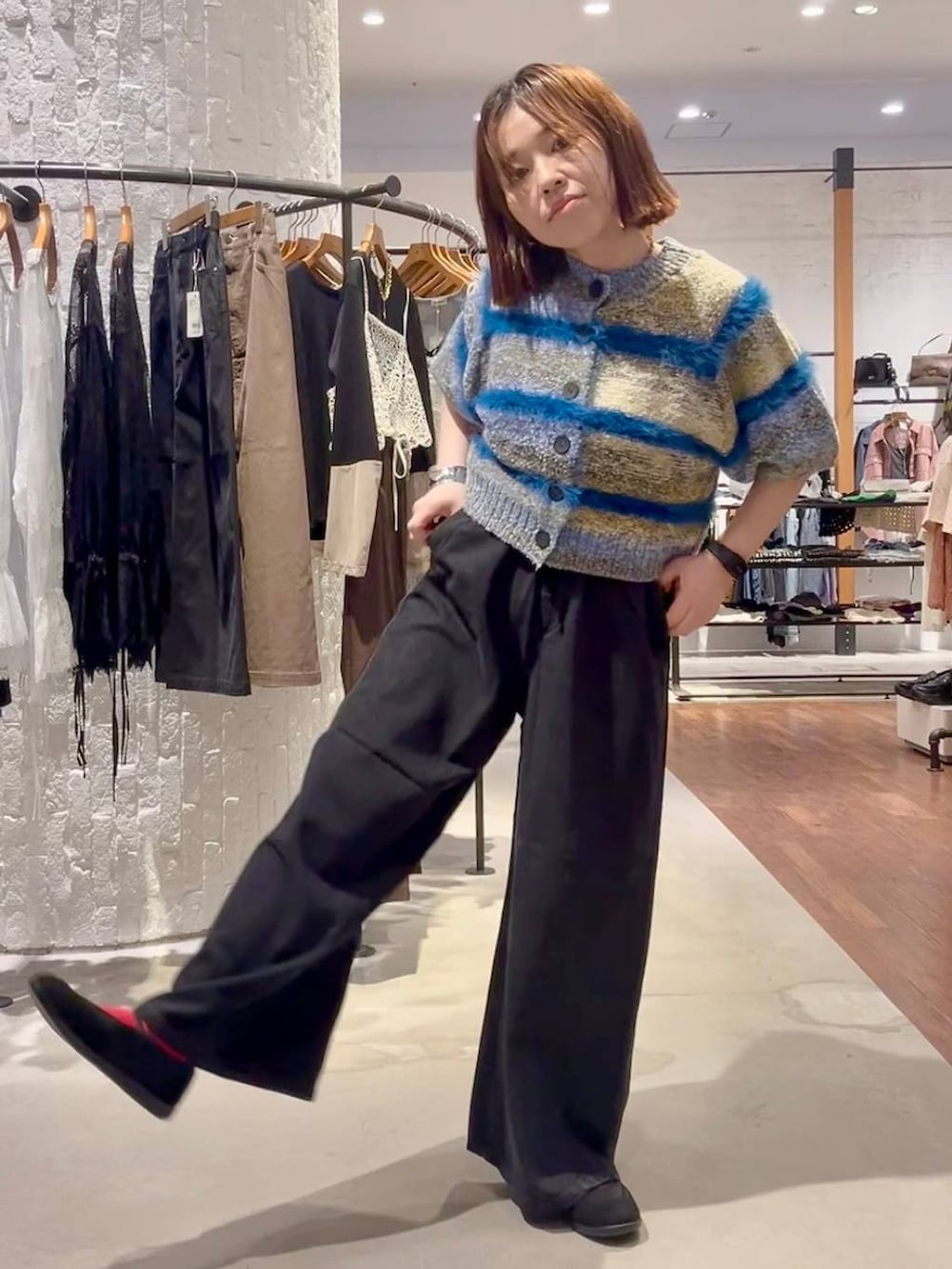 ブラック系のパンプス、ブルー系のニット/セーター、ブラック系のデニムパンツを着用したレディースの夏コーディネートの2枚目の写真