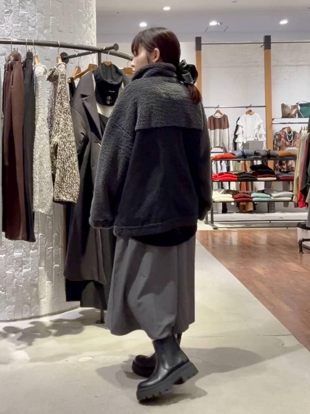 ブラック系のブーツ、ブラック系のデニムジャケット、ブラック系のハンドバッグを着用したレディースの秋コーディネートの5枚目の写真