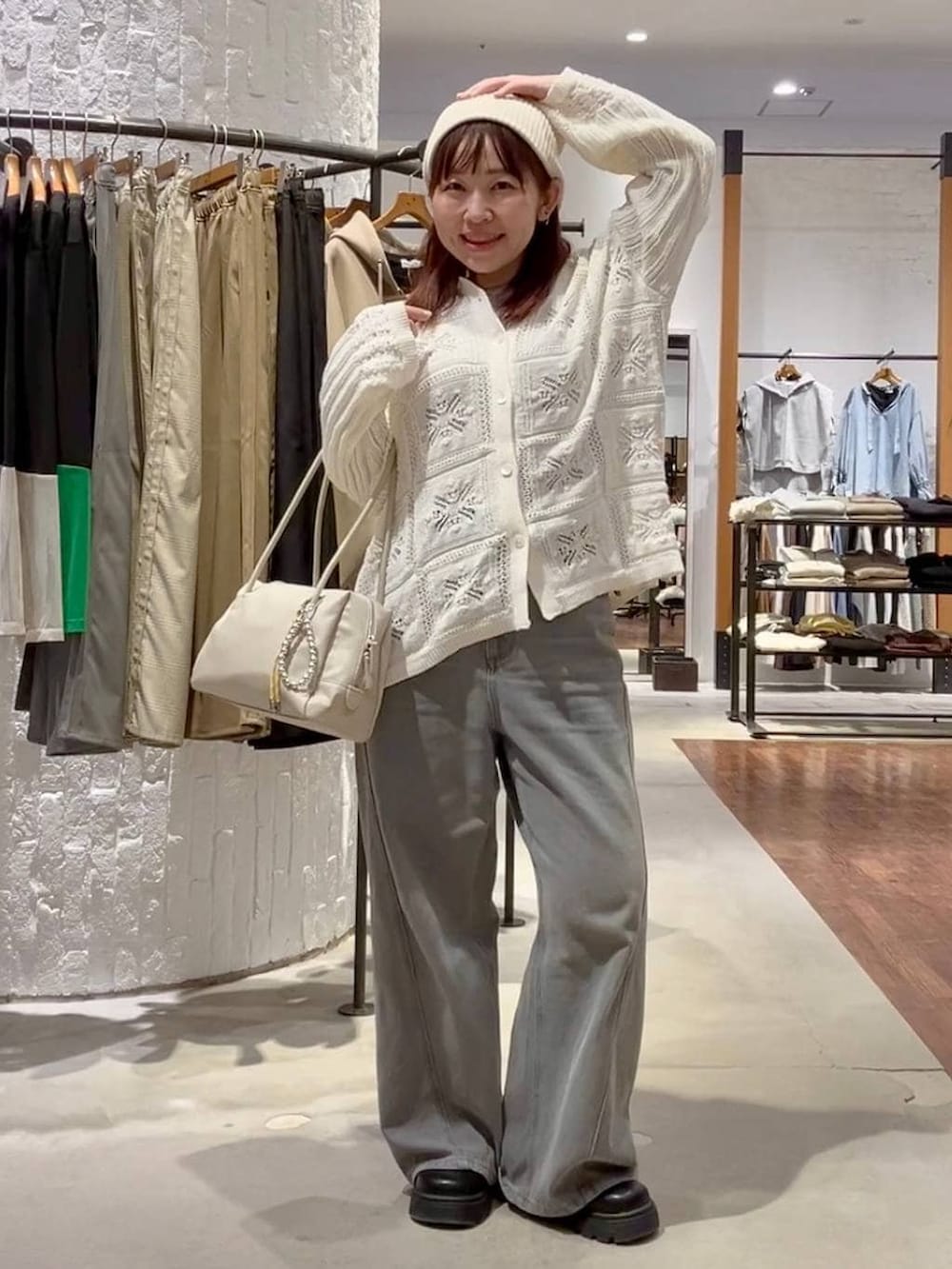 パープル系のTシャツ/カットソー、グレー系のデニムパンツ、ホワイト系のボストンバッグを着用したレディースの冬コーディネートの2枚目の写真