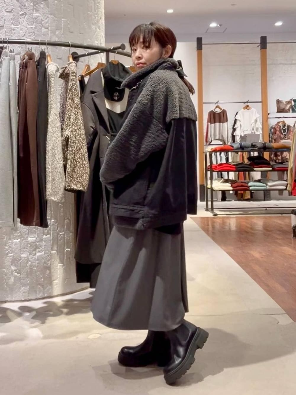 ブラック系のブーツ、ブラック系のデニムジャケット、ブラック系のハンドバッグを着用したレディースの秋コーディネートの3枚目の写真