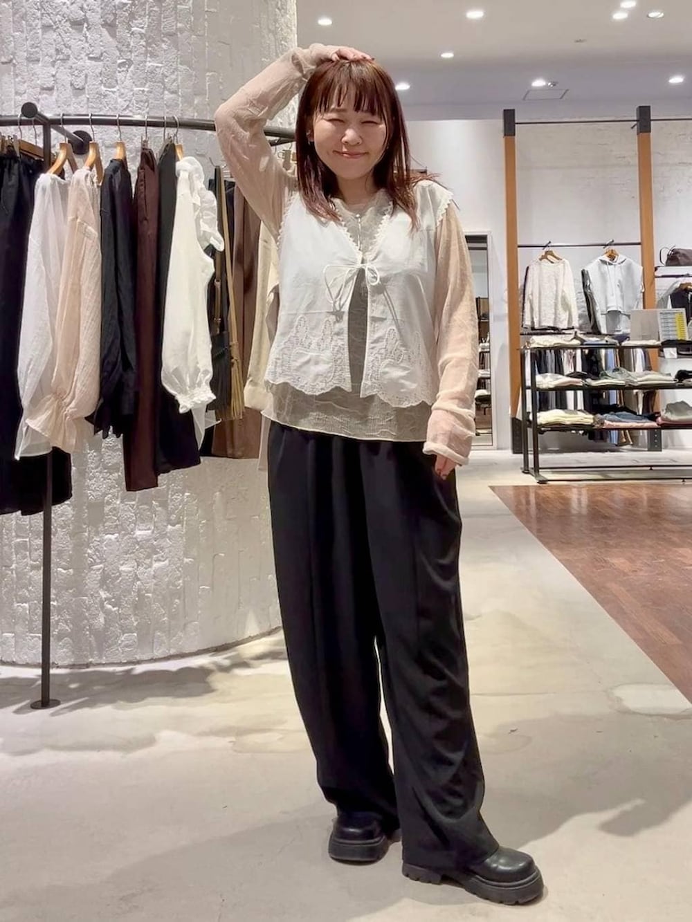 ブラック系のその他パンツ、ブラック系のその他シューズ、ホワイト系のベストを着用したレディースの春コーディネートの2枚目の写真