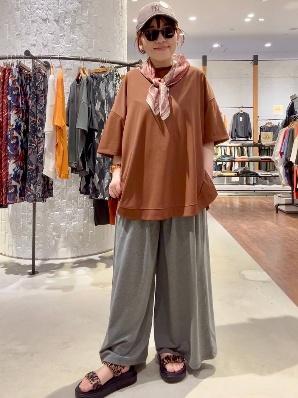 グレー系のその他パンツ、その他のサンダル、ブラウン系のTシャツ/カットソーを着用したレディースの春コーディネートの2枚目の写真