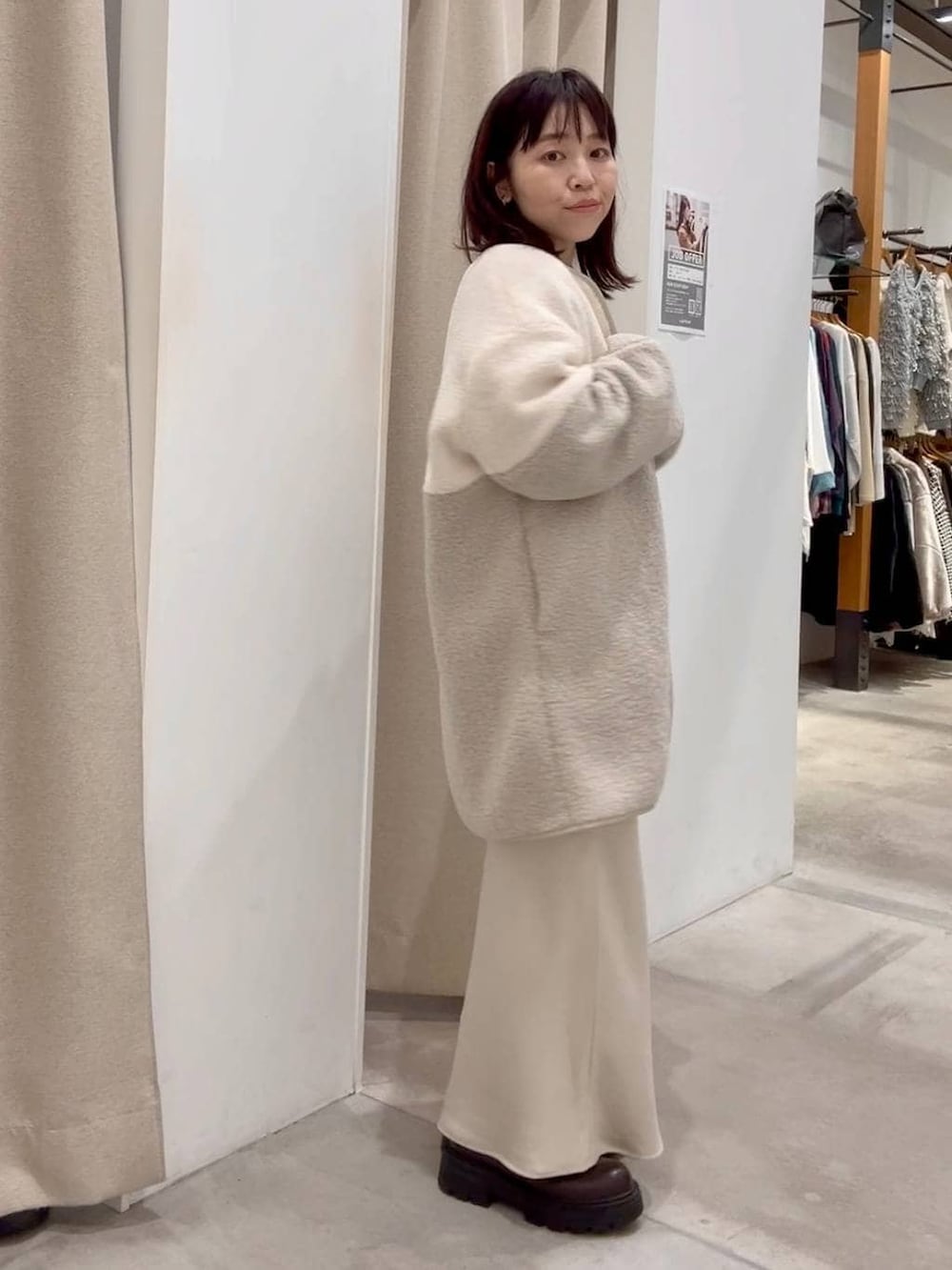 ホワイト系のスカート、ホワイト系のその他アウター、ブラウン系のブーツを着用したレディースの秋コーディネートの4枚目の写真