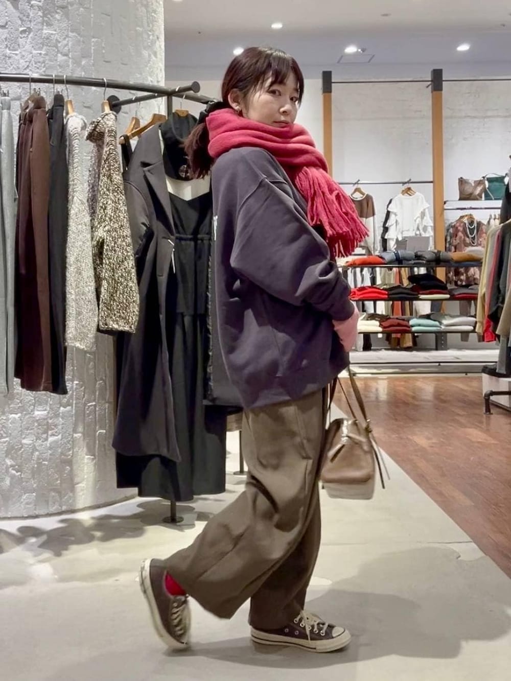 グレー系のニット/セーター、ブラウン系のスニーカー、ブラウン系のボストンバッグを着用したレディースの冬コーディネートの3枚目の写真