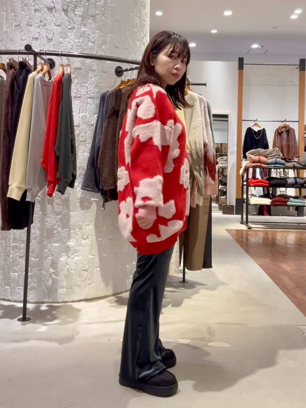 グレー系のニット/セーター、ブルー系のその他パンツ、ブラック系のショルダーバッグを着用したレディースの秋コーディネートの3枚目の写真