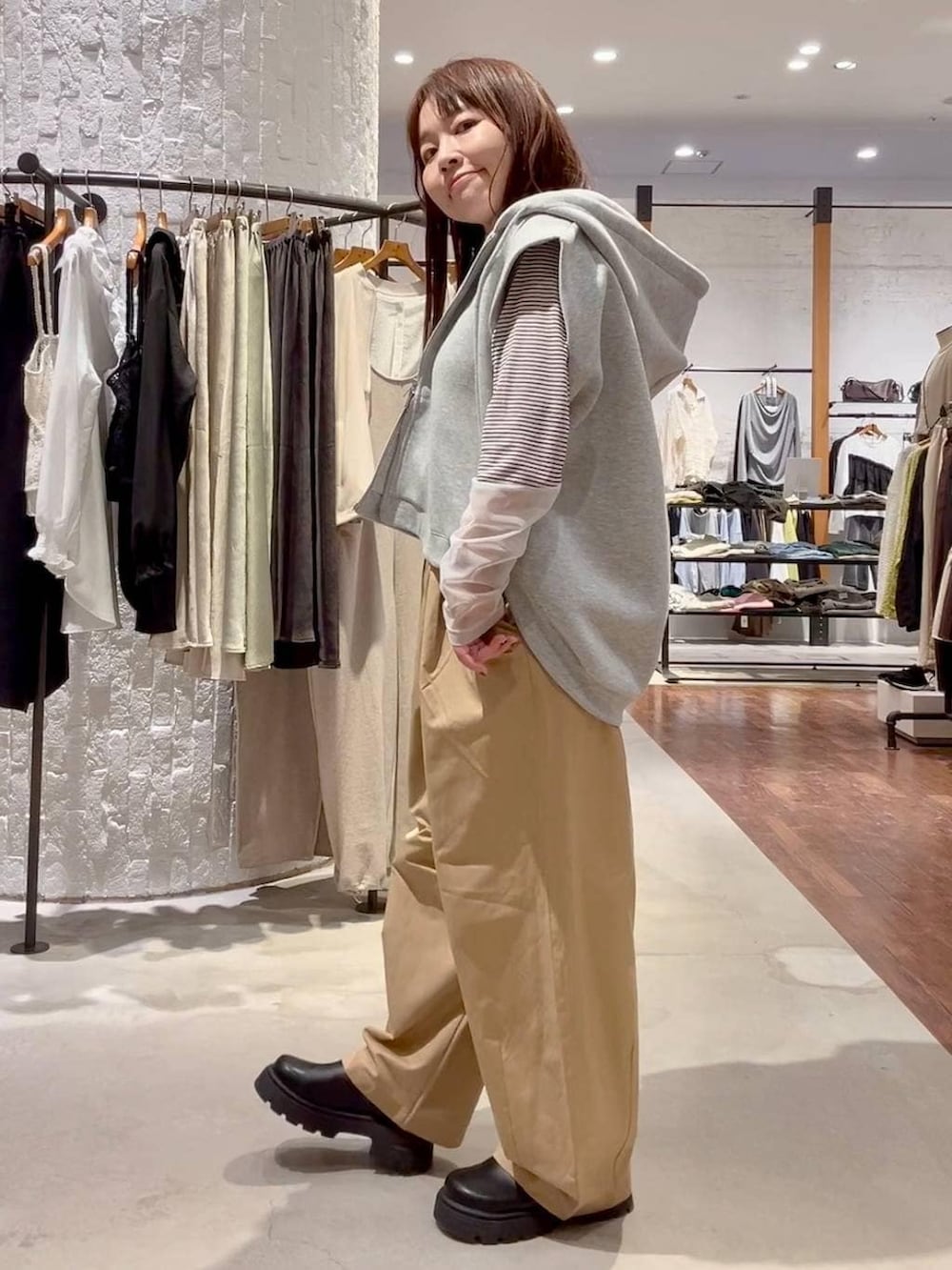 ホワイト系のTシャツ/カットソー、グレー系のベスト、ブラック系のその他シューズを着用したレディースの春コーディネートの3枚目の写真