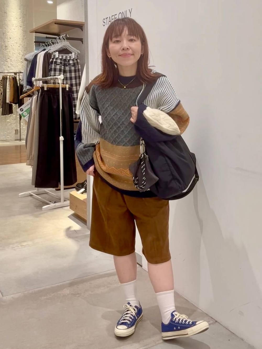 ブルー系のスニーカー、イエロー系のその他パンツ、ブラウン系のニット/セーターを着用したレディースの秋コーディネートの2枚目の写真