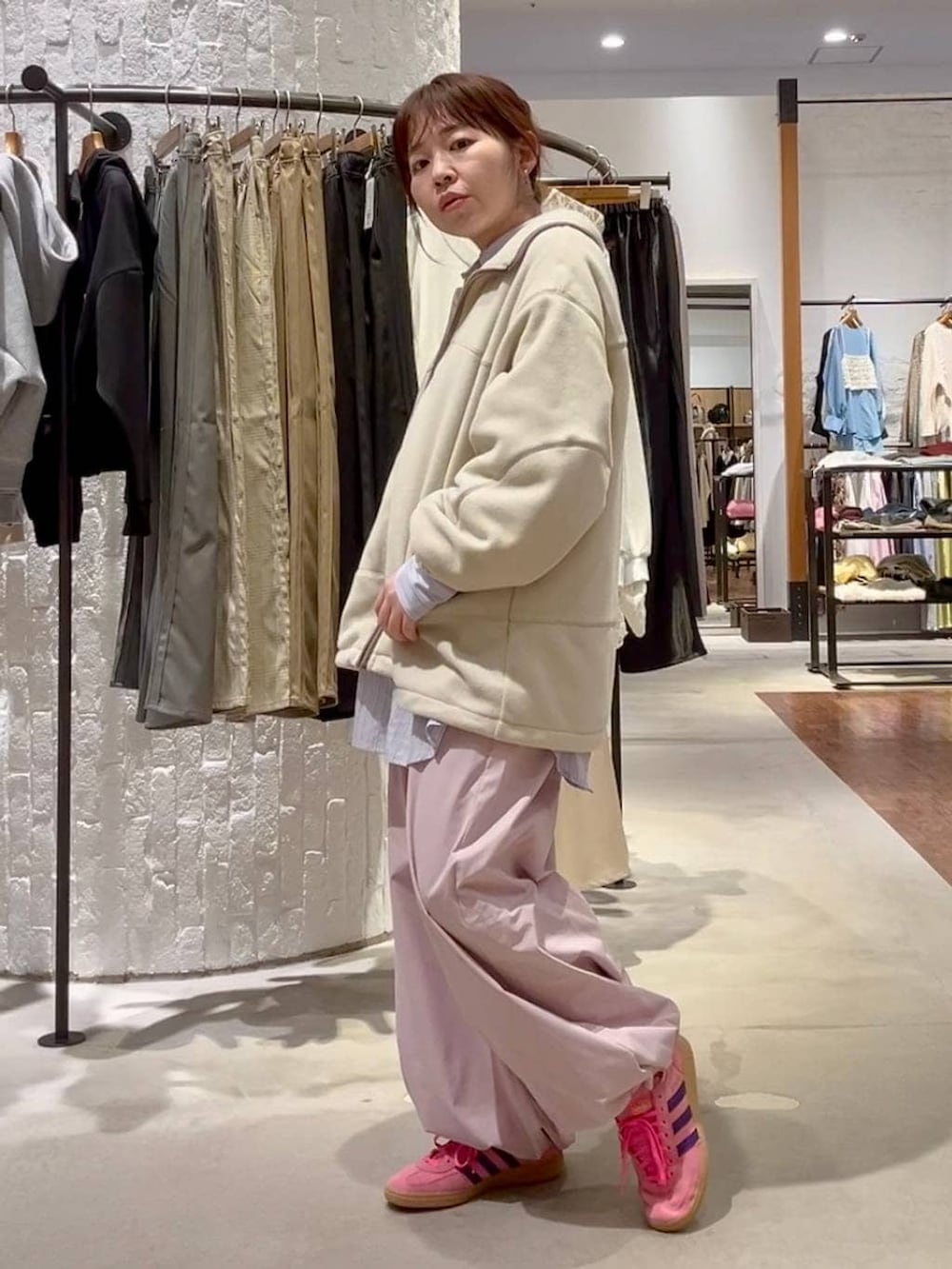 ピンク系のその他パンツ、ホワイト系のブルゾン、ベージュ系のシュシュを着用したレディースの冬コーディネートの4枚目の写真