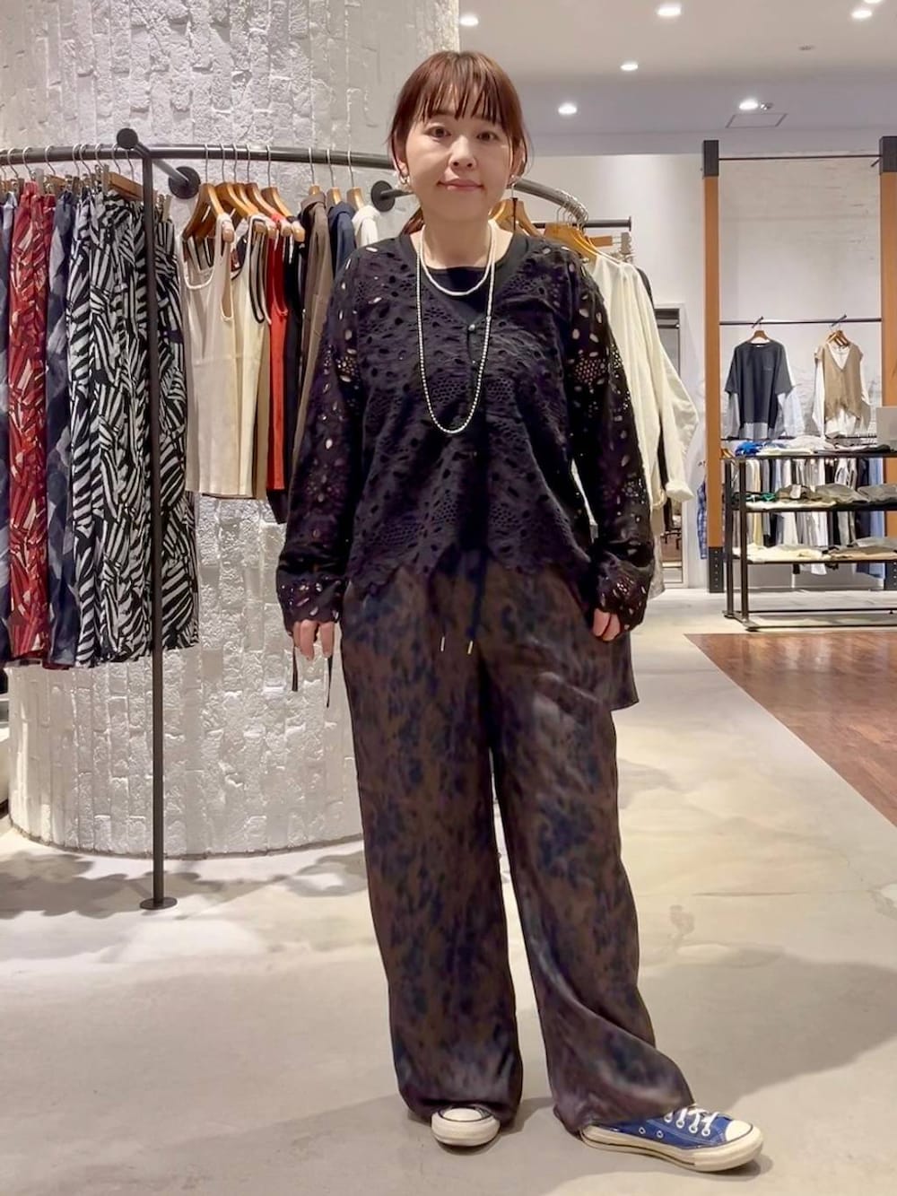 ブルー系のスニーカー、ブラウン系のその他パンツ、ブラック系のショルダーバッグを着用したレディースの春コーディネートの2枚目の写真