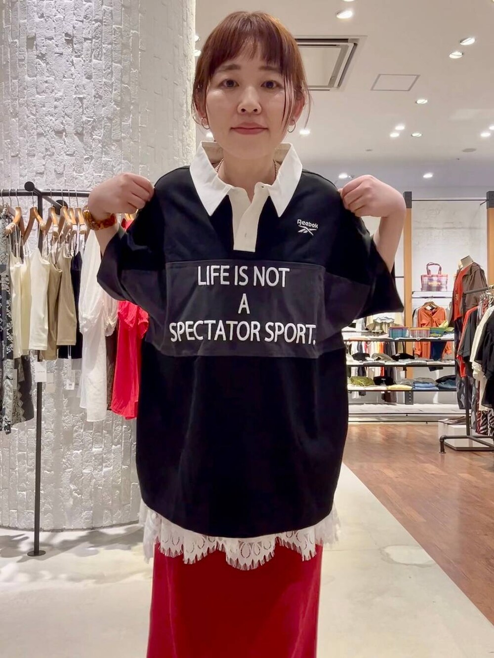 レッド系のスカート、ブラック系のスニーカー、ブラウン系のスニーカーを着用したレディースの春コーディネートの7枚目の写真