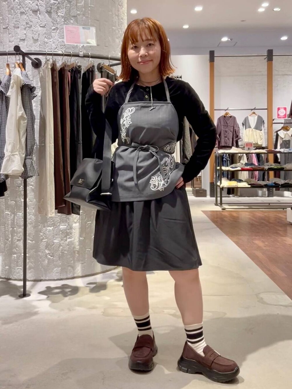 ブラウン系のローファー、ブラック系のトートバッグ、グレー系のその他パンツを着用したレディースの秋コーディネートの6枚目の写真