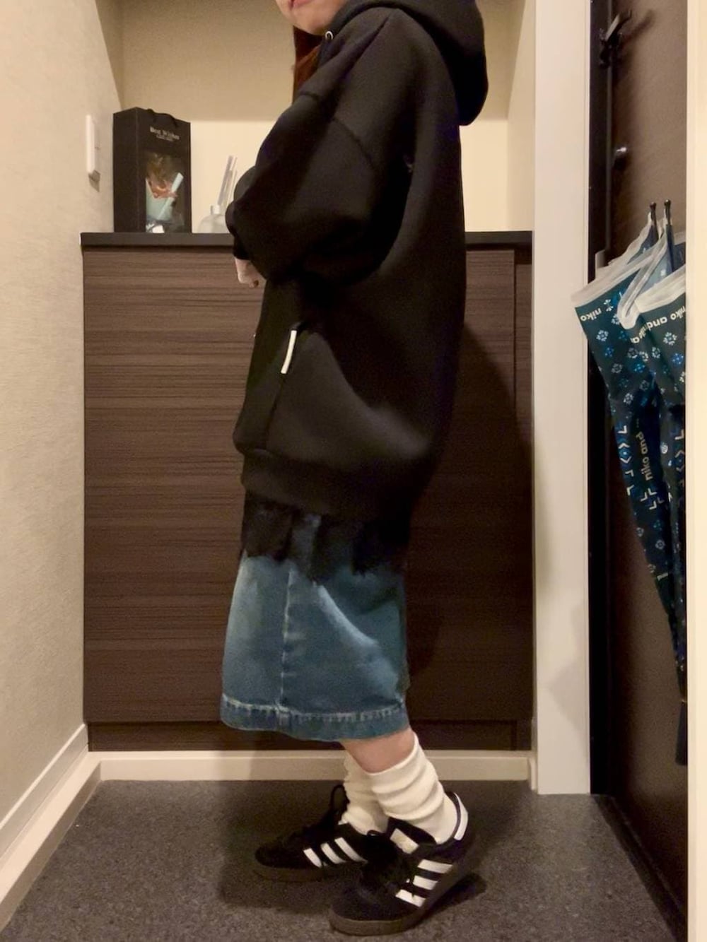 ブラック系のブルゾン、ホワイト系のTシャツ/カットソー、ブラック系のスニーカーを着用したレディースの春コーディネートの3枚目の写真