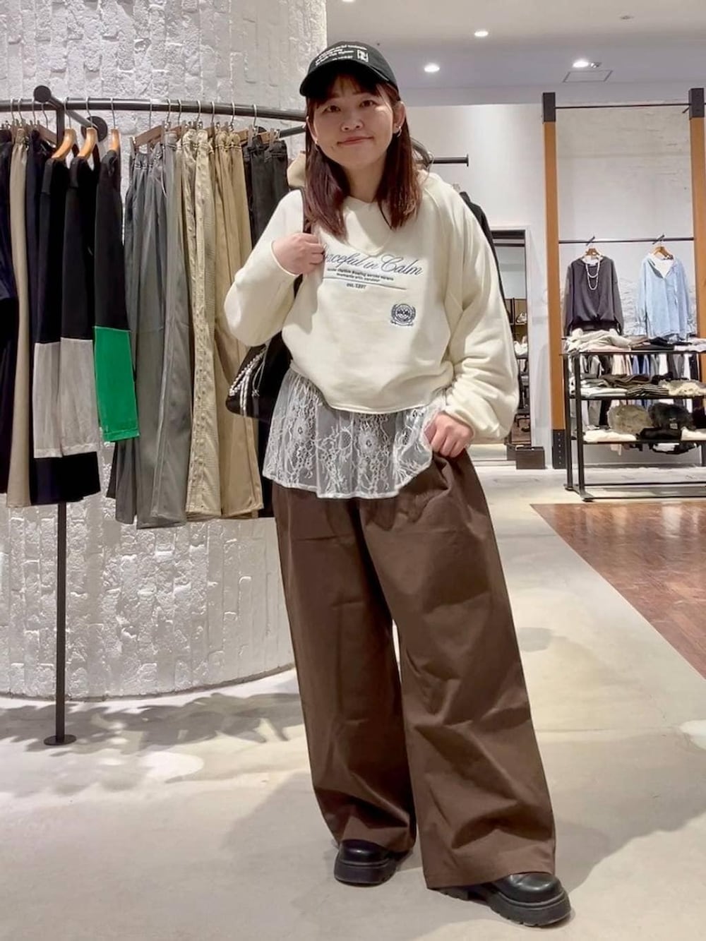 ホワイト系のTシャツ/カットソー、グリーン系のその他パンツ、ブラック系のボストンバッグを着用したレディースの冬コーディネートの2枚目の写真