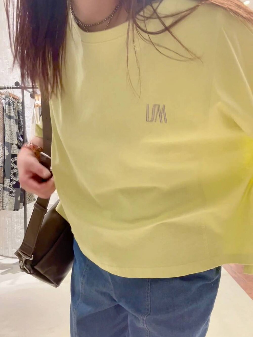 ブラウン系のショルダーバッグ、ホワイト系のサンダル、ブルー系のデニムパンツを着用したレディースの春コーディネートの6枚目の写真