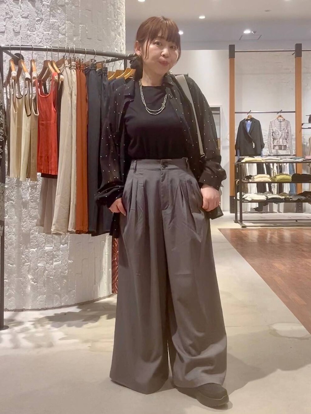 グレー系のショルダーバッグ、ブラック系のその他シューズ、ブラック系のTシャツ/カットソーを着用したレディースの春コーディネートの2枚目の写真