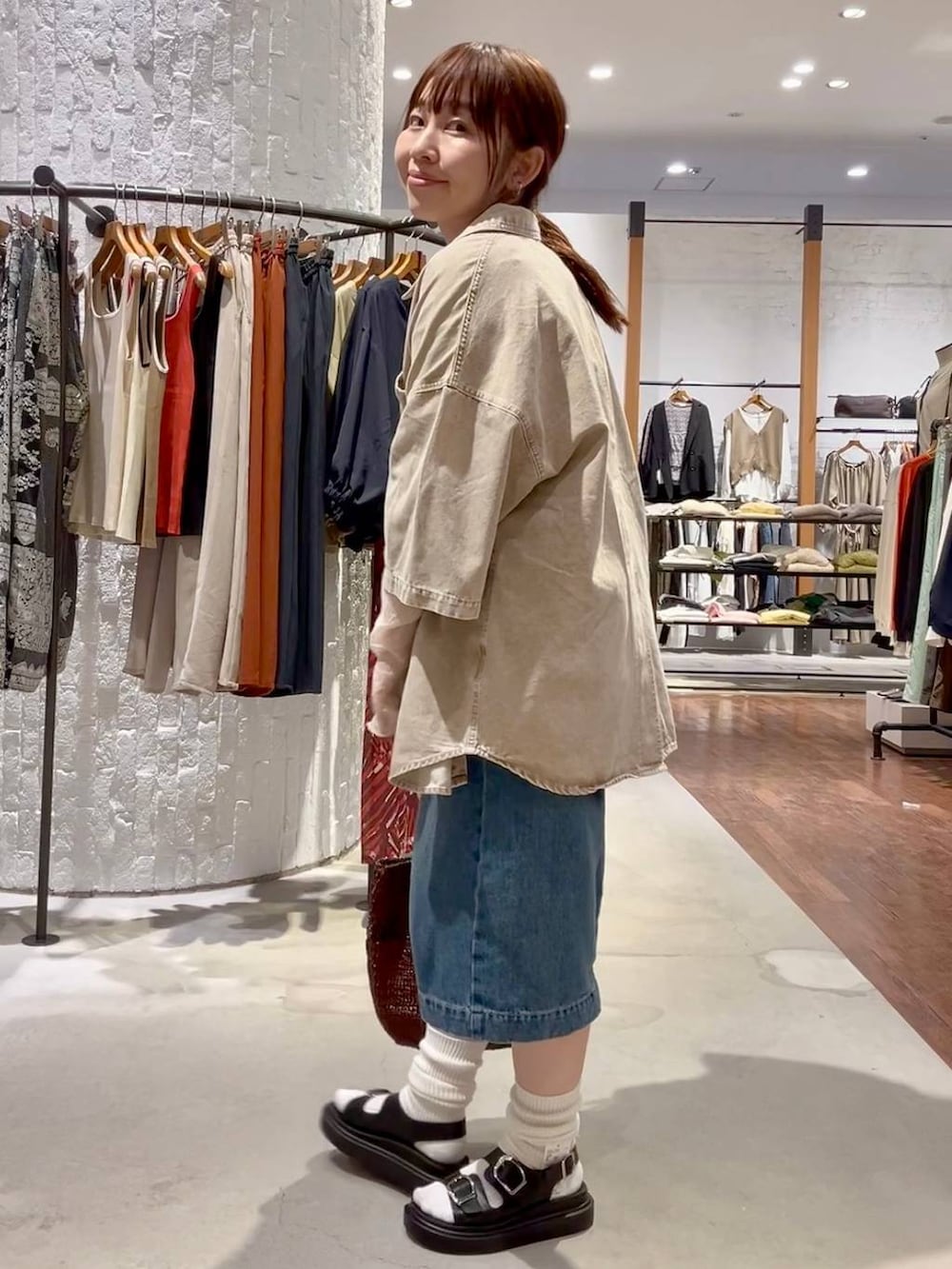 ブラック系のサンダル、ブルー系のデニムパンツ、ホワイト系のTシャツ/カットソーを着用したレディースの春コーディネートの3枚目の写真