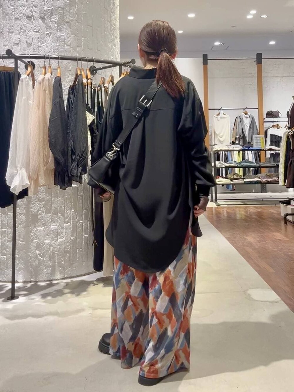 ブルー系のその他パンツ、ブラック系のショルダーバッグ、ブラック系のシャツ/ブラウスを着用したレディースの春コーディネートの4枚目の写真