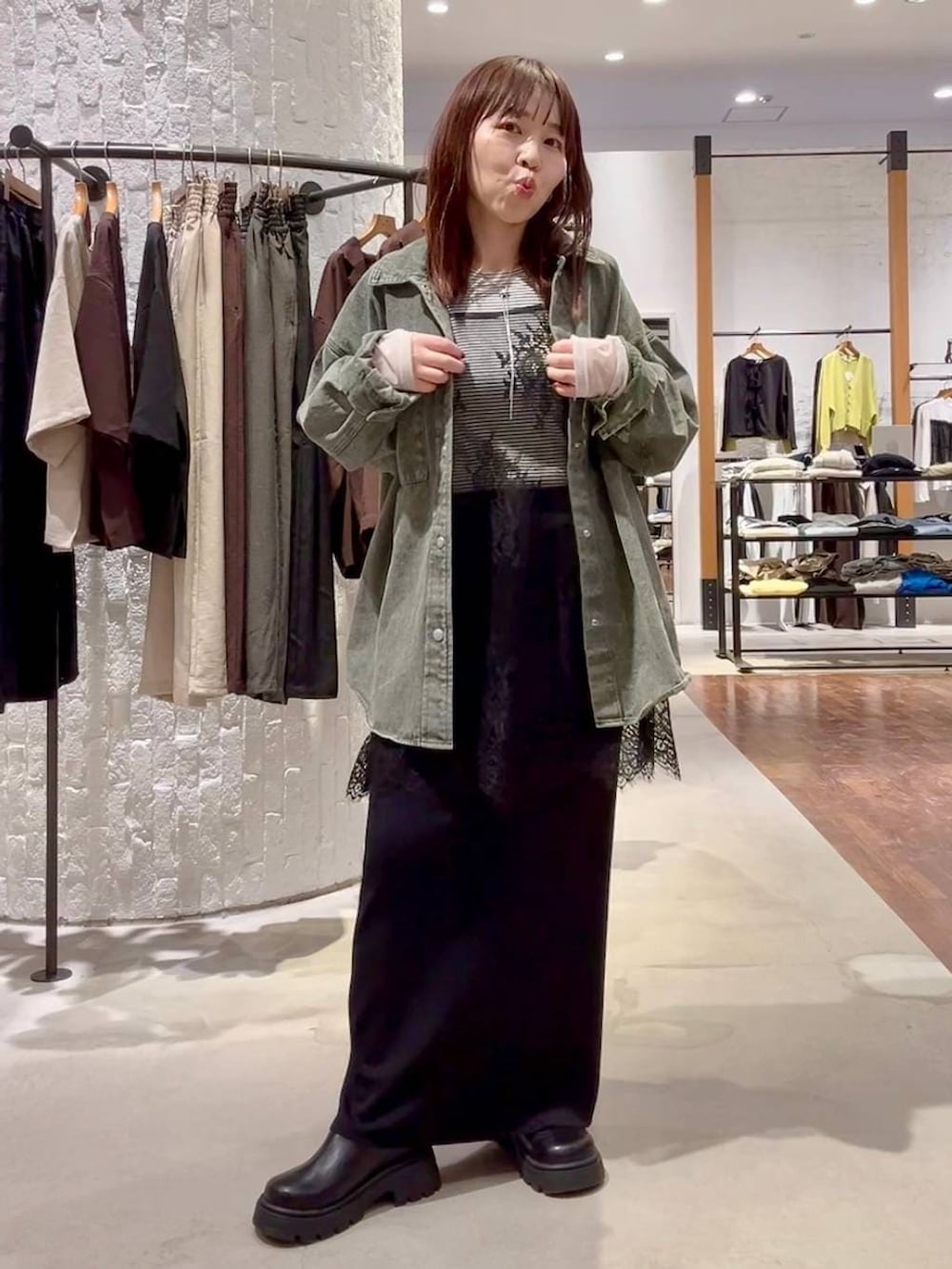 ホワイト系のTシャツ/カットソー、ブラック系のスカート、グリーン系のシャツ/ブラウスを着用したレディースの春コーディネートの7枚目の写真