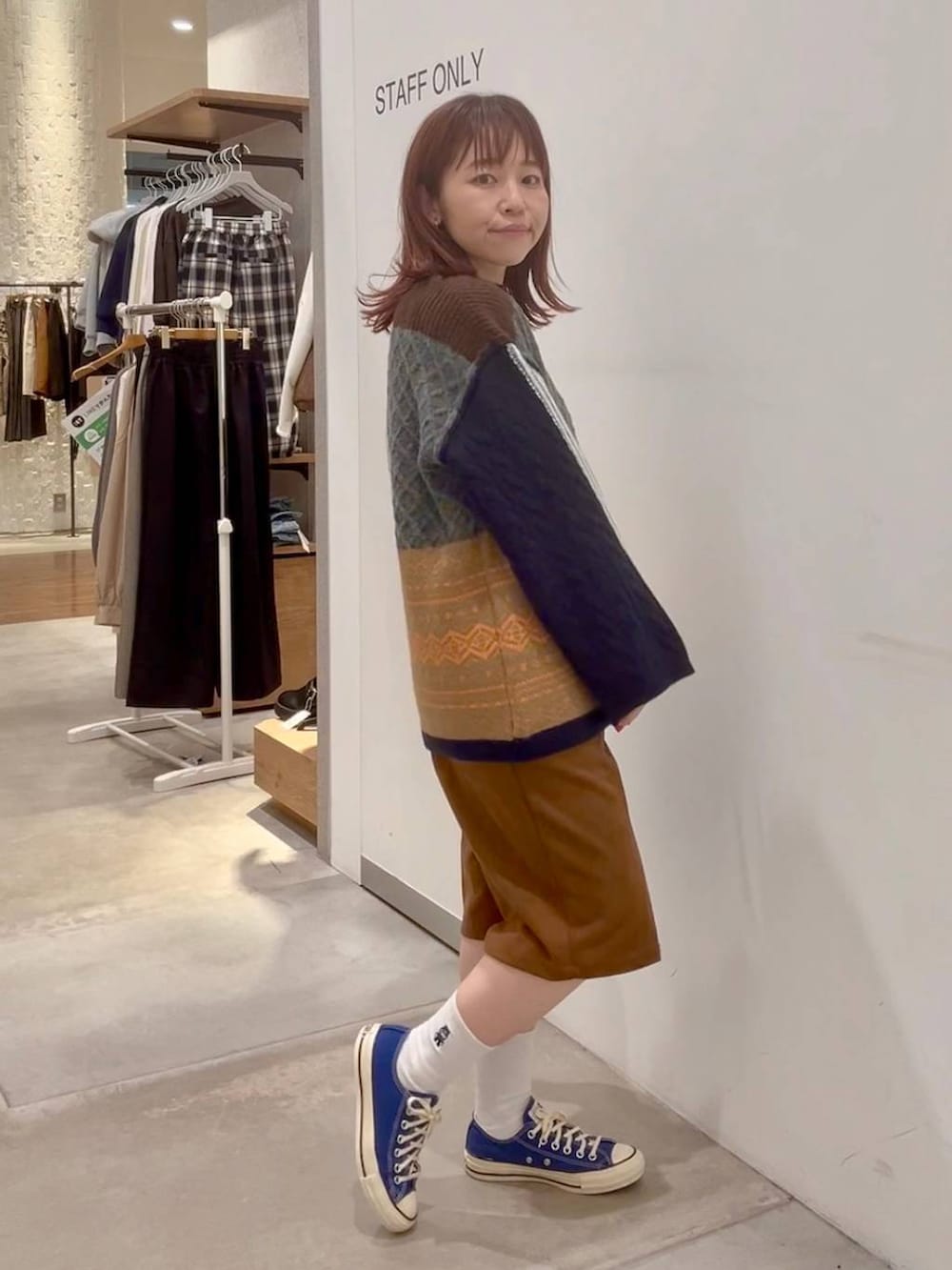 ブルー系のスニーカー、イエロー系のその他パンツ、ブラウン系のニット/セーターを着用したレディースの秋コーディネートの3枚目の写真