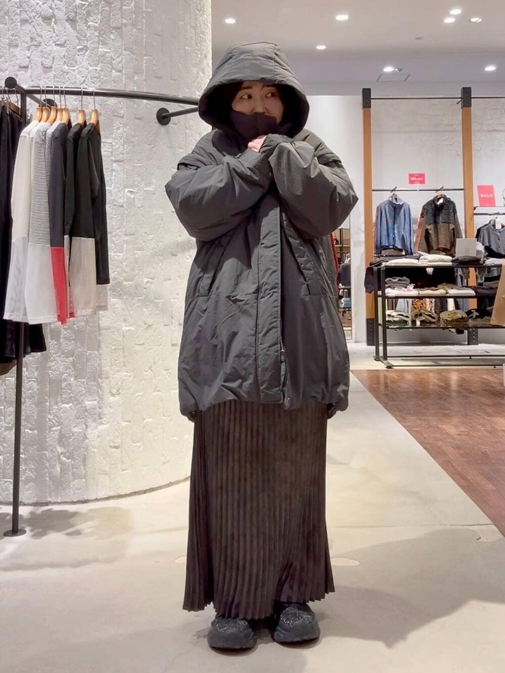 ホワイト系のTシャツ/カットソー、グレー系のその他アウター、グレー系のスカートを着用したレディースの冬コーディネートの2枚目の写真