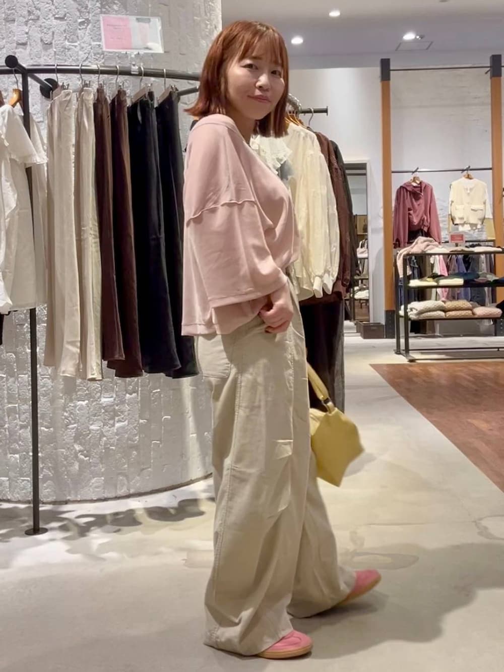 ベージュ系のその他パンツ、イエロー系のショルダーバッグ、ピンク系のTシャツ/カットソーを着用したレディースの秋コーディネートの4枚目の写真