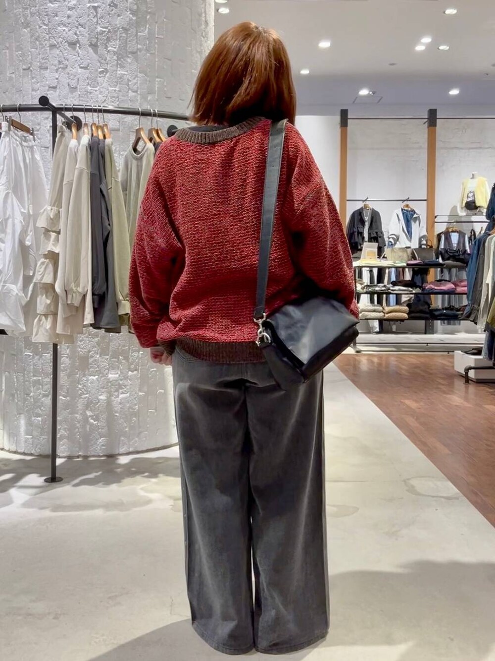 ブラック系のTシャツ/カットソー、グレー系のデニムパンツ、レッド系のニット/セーターを着用したレディースの秋コーディネートの5枚目の写真