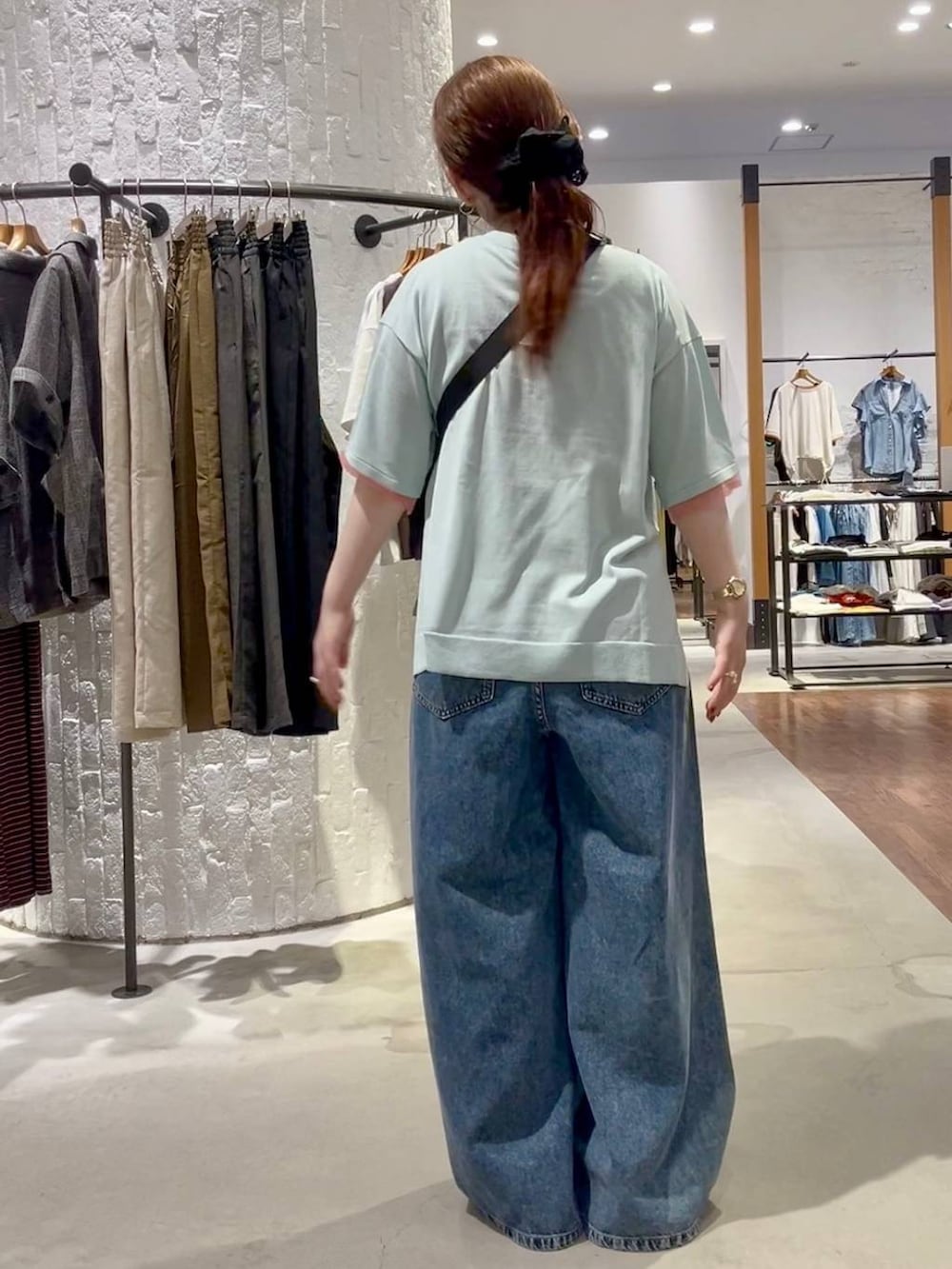 ブルー系のニット/セーター、ブルー系のデニムパンツ、ブラック系のサンダルを着用したレディースの夏コーディネートの4枚目の写真