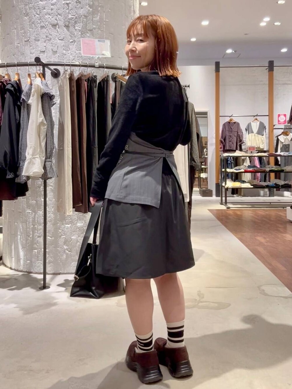 ブラウン系のローファー、ブラック系のトートバッグ、グレー系のその他パンツを着用したレディースの秋コーディネートの4枚目の写真