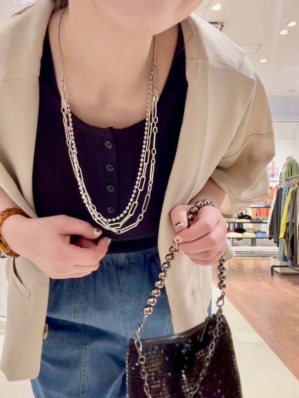 ブラック系のサンダル、ベージュ系のテーラードジャケット、ブラック系のショルダーバッグを着用したレディースの春コーディネートの6枚目の写真